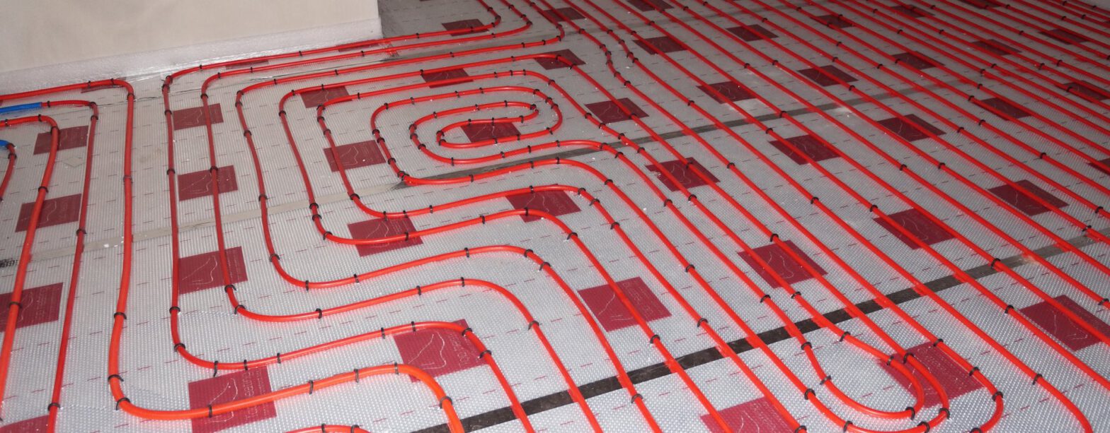 Verlegte Heizkreise einer Fußbodenheizung auf Systemplatten in einem Rohbau